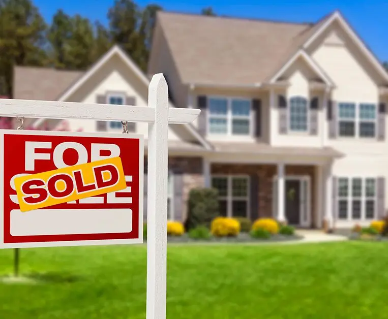 A house with a for sale sign in front of it